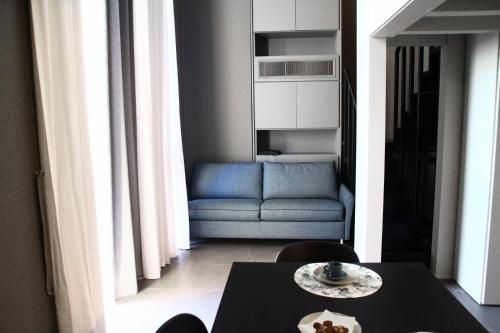sala de estar con mesa y sofá azul en Dimore al Te, en Mantua