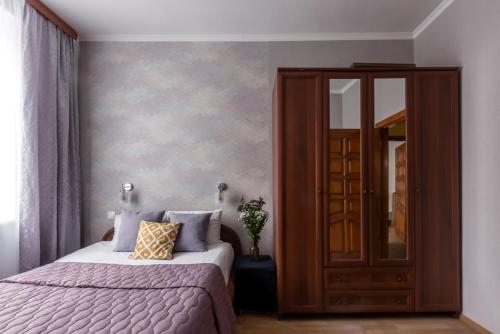 a bedroom with a bed and a medicine cabinet at Kvart-Hotel Harmonia in Moscow