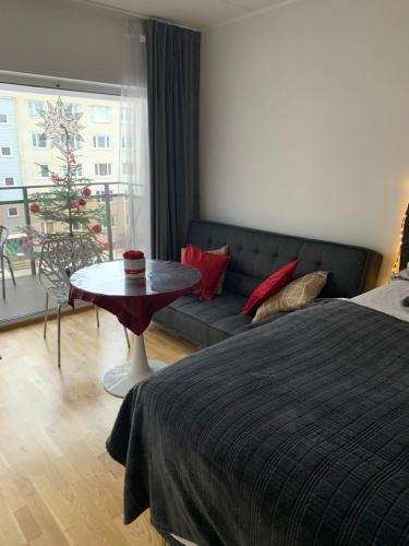 a bedroom with a bed and a couch and a table at Oja 118 Apartment in Pärnu