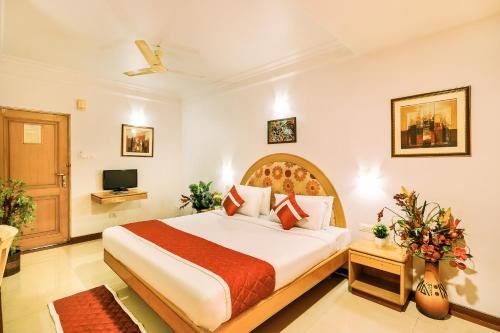 バンガロールにあるOctave Crystal Heightsのベッドとテレビ付きのホテルルーム
