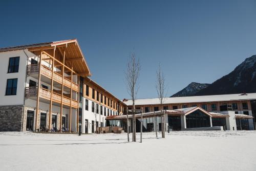 a building in the snow in front of a mountain at aja Ruhpolding in Ruhpolding