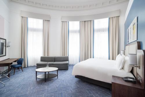 a hotel room with a bed and a desk at voco Grand Central Glasgow by IHG in Glasgow