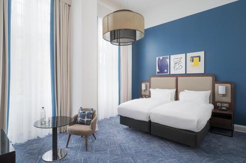 a hotel room with a bed and a table at voco Grand Central Glasgow by IHG in Glasgow