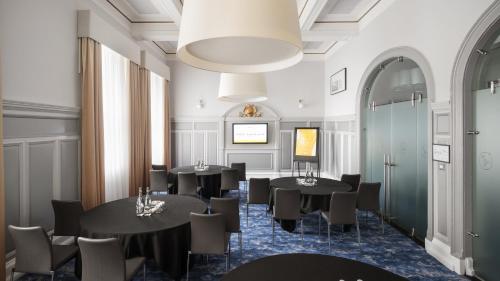 a dining room with black tables and chairs at voco Grand Central Glasgow by IHG in Glasgow