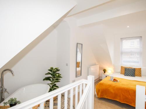 een witte zolderslaapkamer met een bed en een trap bij Portside in Weymouth