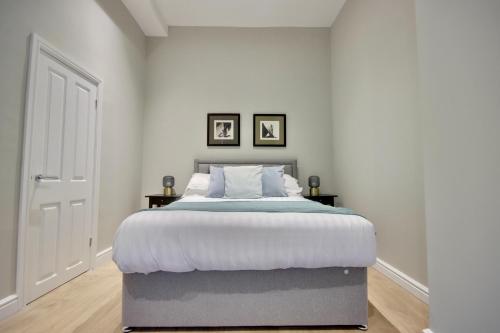 a bedroom with a large bed and two pictures on the wall at Orange Grove Hotel & Gardens in Southampton