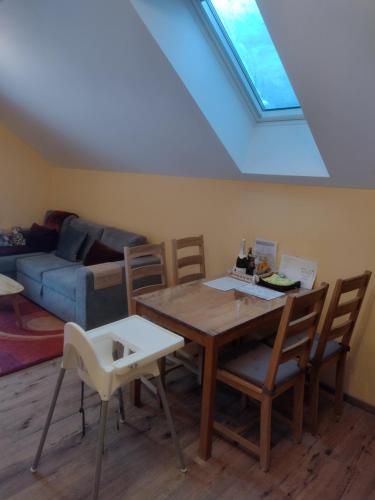 ein Wohnzimmer mit einem Tisch, Stühlen und einem Dachfenster in der Unterkunft Ferienwohnung Anna in Semmering