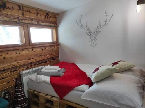 une chambre avec un lit avec une couverture rouge dessus dans l'établissement Chałpa na skarpie, à Meszna