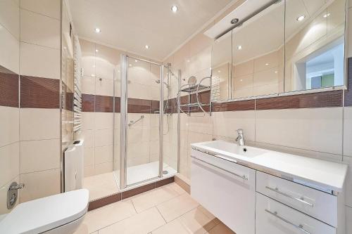 ein Bad mit einer Dusche, einem Waschbecken und einem WC in der Unterkunft Grömitz Center II Wohnung 25 in Grömitz