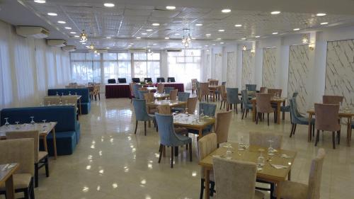 a dining room with tables and chairs and a room filled with tables and chairsktop at Jewel Assiut Hotel in Asyut