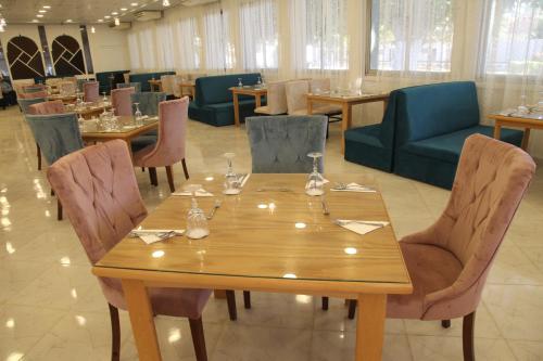 a dining room with a wooden table and chairs at Jewel Assiut Hotel in Asyut