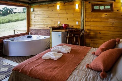 um quarto com uma banheira e uma cama com toalhas em Refugio monte itapeva em Torres