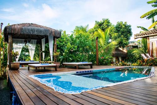 a backyard with a pool and a wooden deck at Barra Suítes in Barra Grande