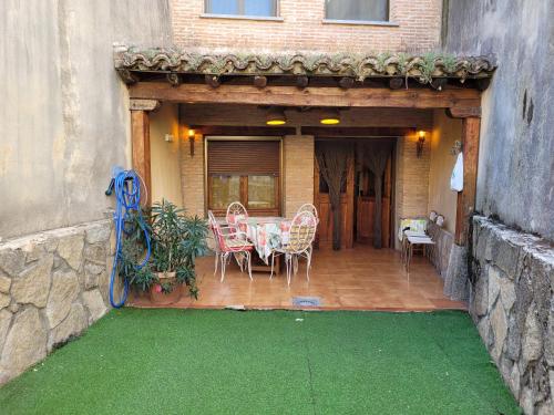 a patio with a table and chairs on it at Casa Rural La Vid in Cadalso de los Vidrios