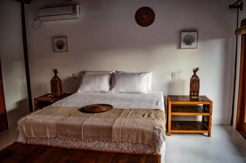 a bedroom with a bed and two night stands at Barra Suítes in Barra Grande
