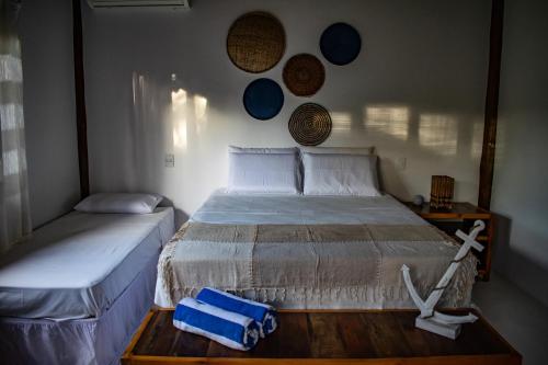 a bedroom with a bed with a blue bag on it at Barra Suítes in Barra Grande