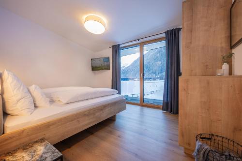 a bedroom with a bed and a large window at Apartment Mountainview in Neustift im Stubaital