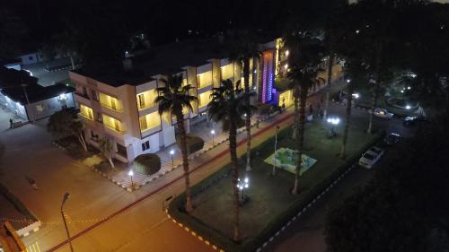 an overhead view of a building at night with palm trees at Jewel Assiut Hotel in Asyut