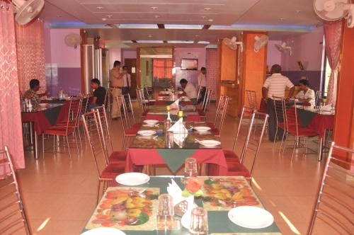 a restaurant with long tables with plates of food at Hotel Dooars Mountain in Alīpur Duār