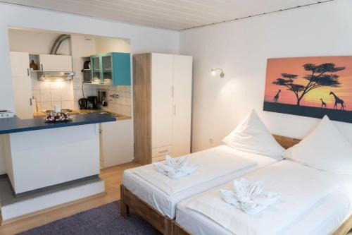 a bedroom with a white bed and a kitchen at Apart-2-OG-Nr2 in Darmstadt
