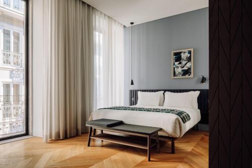 a bedroom with a bed with a table and a window at Hotel Hotel - Member of Design Hotels in Lisbon
