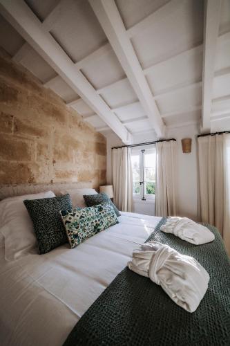 a bedroom with a large white bed with pillows at Agroturismo Rafal Rubí in Alaior