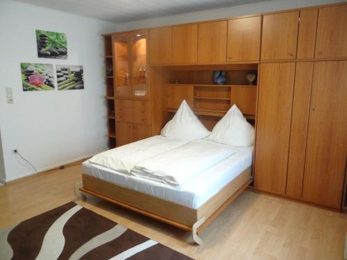 um quarto com uma cama e armários de madeira em Apart-EG-01 em Darmstadt