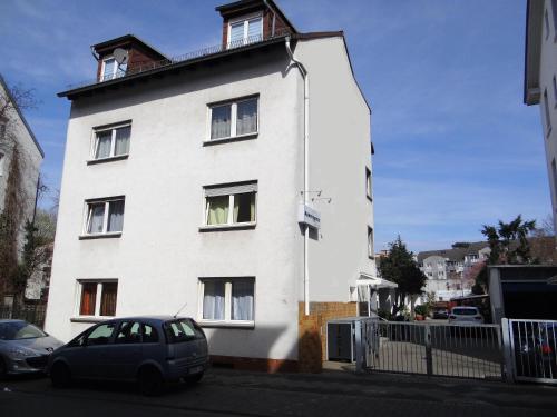 a white house with a car parked in front of it at Apart-EG-01 in Darmstadt