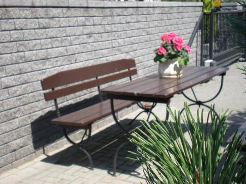 a wooden bench with a vase of flowers on it at Apartamenty KopeX in Kostrzyn