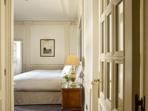 a bedroom with a bed and a lamp on a table at Hotel Fenix Gran Meliá - The Leading Hotels of the World in Madrid
