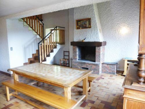 a living room with a table and a fireplace at Gîte familial près de La Chaise-Dieu avec jardin, terrasse, jeux pour enfants et équipements bébé - FR-1-582-287 in Saint-Didier-sur-Doulon