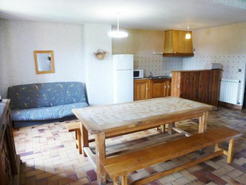a living room with a table and a blue couch at Gîte familial près de La Chaise-Dieu avec jardin, terrasse, jeux pour enfants et équipements bébé - FR-1-582-287 in Saint-Didier-sur-Doulon