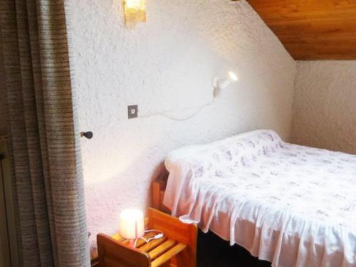 a bedroom with a bed and a candle on a table at Gîte familial près de La Chaise-Dieu avec jardin, terrasse, jeux pour enfants et équipements bébé - FR-1-582-287 in Saint-Didier-sur-Doulon