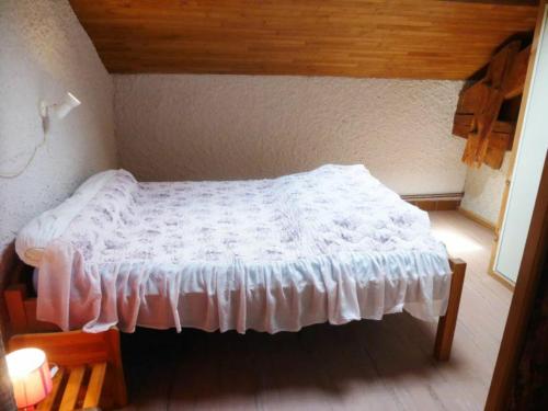 a small bedroom with a white bed in a room at Gîte familial près de La Chaise-Dieu avec jardin, terrasse, jeux pour enfants et équipements bébé - FR-1-582-287 in Saint-Didier-sur-Doulon