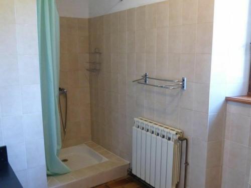 a bathroom with a shower with a tub and a radiator at Gîte familial près de La Chaise-Dieu avec jardin, terrasse, jeux pour enfants et équipements bébé - FR-1-582-287 in Saint-Didier-sur-Doulon