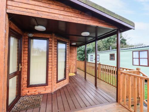 a wooden deck with awning on a house at Roe Deer Lodge in Newton Stewart