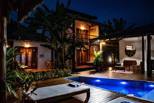a villa with a swimming pool at night at Barra Suítes in Barra Grande