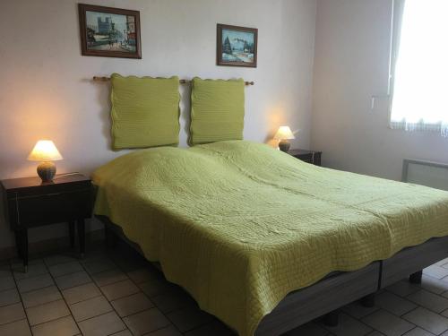 sypialnia z łóżkiem z zieloną narzutą i 2 lampami w obiekcie Gîte Sionviller, 3 pièces, 4 personnes - FR-1-584-38 
