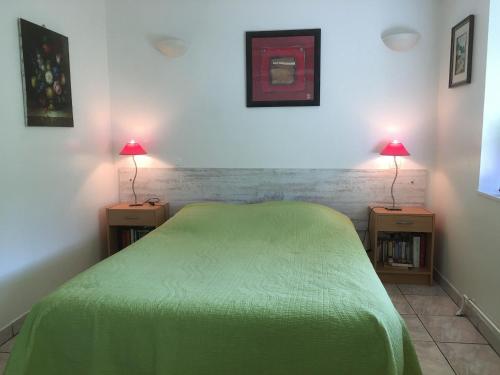a bedroom with a green bed and two lamps on tables at Charmant Gîte en Lorraine, Proche Nancy et Vosges, Terrasse et Confort Tout Équipé - FR-1-584-59 in Rozelieures