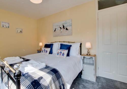 a bedroom with a bed with blue and white pillows at Maggie May in Whitby