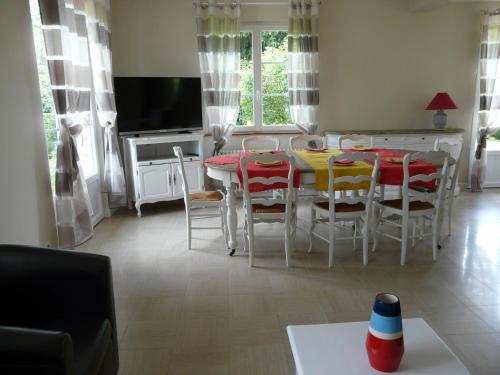 a living room with a table and chairs and a television at Maison en pierre rénovée, 3 chambres, jardin clos, équipée, calme et proche étang à Senonches - FR-1-581-36 in Senonches