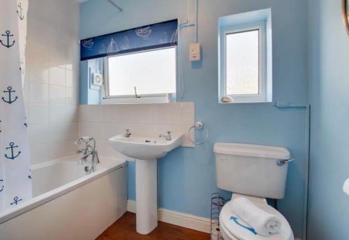 Baño azul con aseo y lavamanos en Maggie May en Whitby