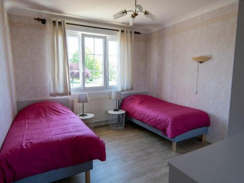 2 Betten in einem Zimmer mit rosa Bettwäsche und einem Fenster in der Unterkunft Gîte Étain, 4 pièces, 6 personnes - FR-1-585-57 in Étain