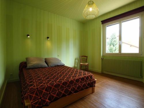 een groene slaapkamer met een bed en een raam bij Gîte Retournac, 3 pièces, 4 personnes - FR-1-582-248 in Retournac