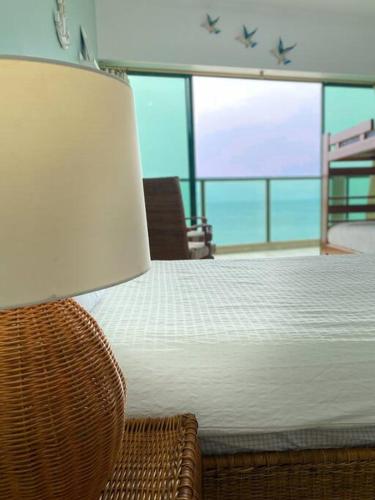 a bedroom with a bed with a lamp and a chair at Suite en Colón Miramar con Netflix para 8 personas in Salinas