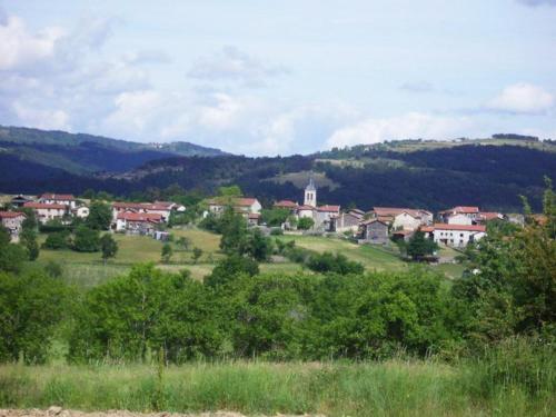 a town on a hill with trees and a church at Ancien pigeonnier restauré avec terrasse, terrain clos et équipements bébé à Sarlanges, Retournac - FR-1-582-167 in Retournac