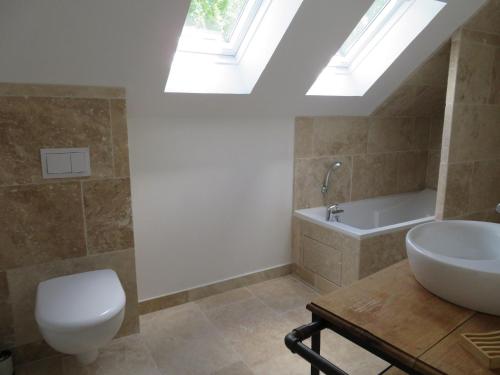a bathroom with a toilet and a sink and a bath tub at Maison chaleureuse en forêt du Perche avec cheminée, jeux pour enfants et grand jardin - FR-1-581-51 in Senonches