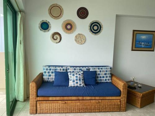 a couch in a living room with plates on the wall at Suite en Colón Miramar con Netflix para 8 personas in Salinas