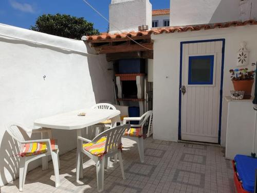a patio with a table and chairs and a door at Casa Ericeira in Ericeira