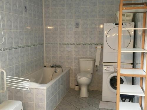 a bathroom with a bath tub and a toilet at Gîte Flainval, 6 pièces, 10 personnes - FR-1-584-37 
